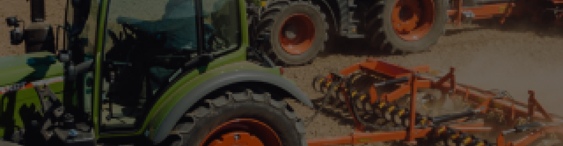 Két traktor szántóföldön, mögöttük talajművelő gépek; poros, napos táj.
